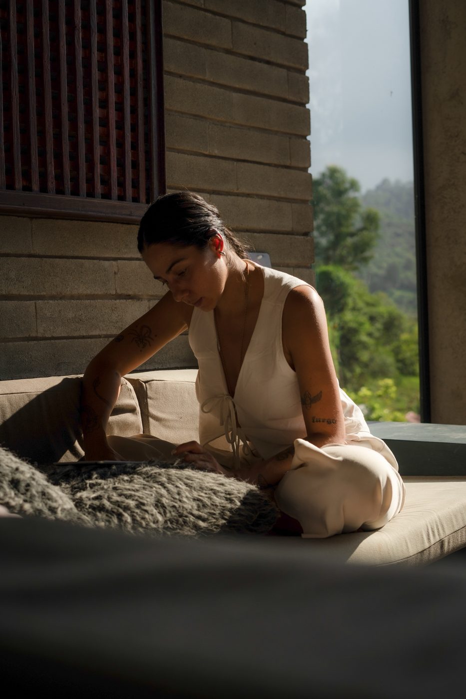 Daniella escribiendo junto a una ventana con vista a la montaña